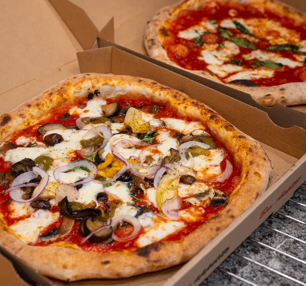 Une pizza aux légumes grillés dans sa boîte Buon appetito