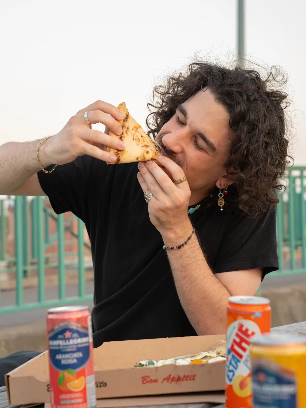 Un garçon croque une part, une Estathé posée sur la boîte